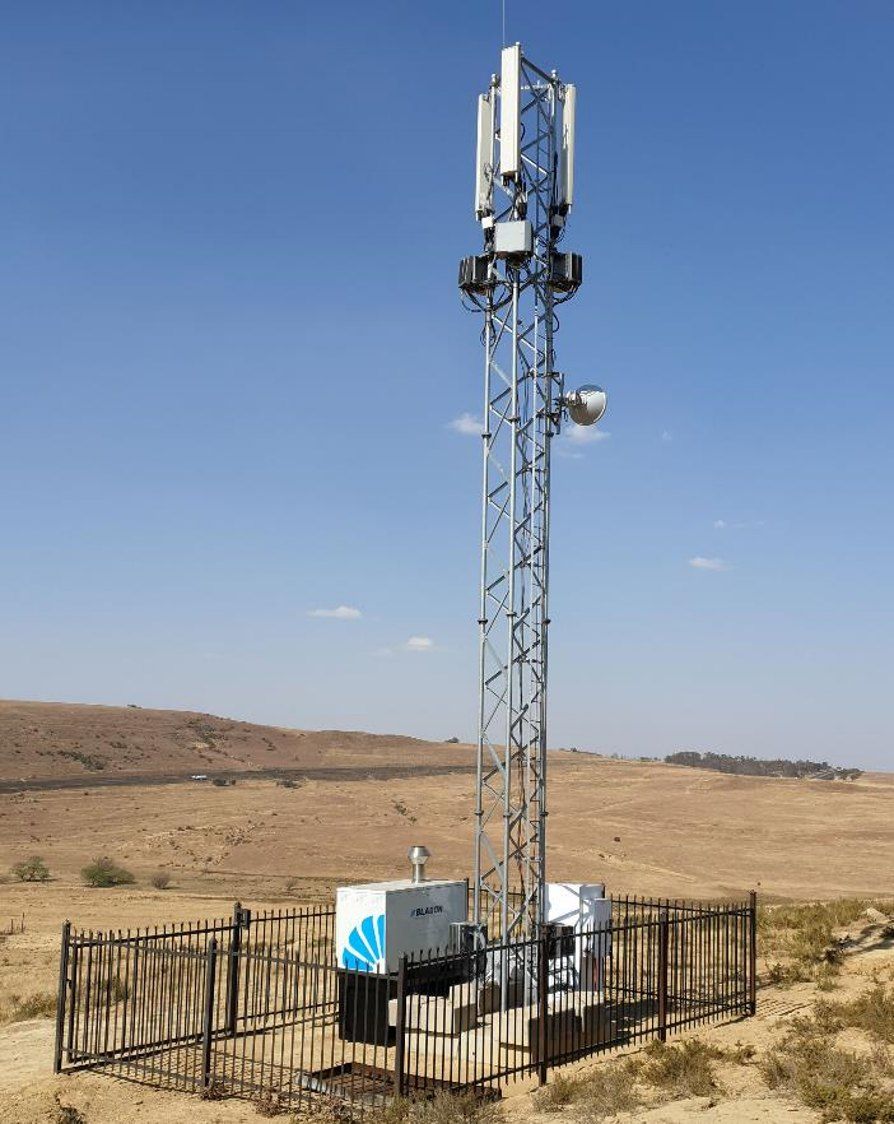 Bladon microturbine genset in a palisade-fenced compound at the base of a lattice telecom tower on a remote off-grid site